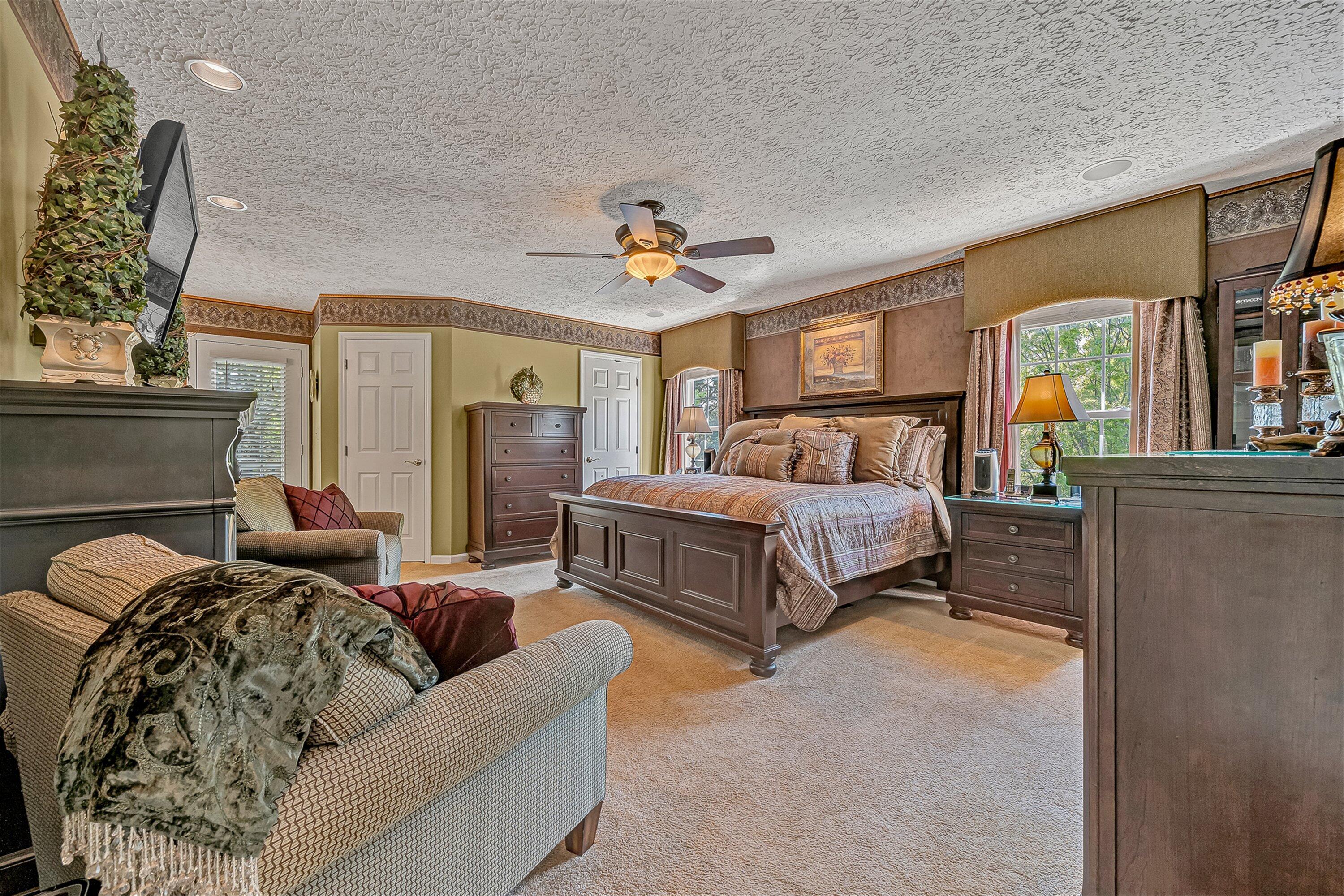4723 Norwood Street Southwest Roanoke, VA 24018 - Photo 48 of 84 a spacious bedroom with a bed a couch and a chandelier