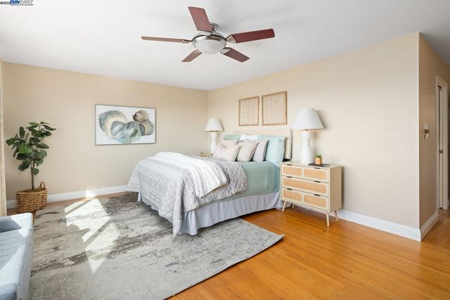 a bedroom with a bed lamp and a potted plant