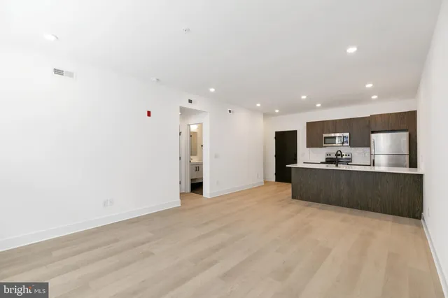 a view of kitchen with refrigerator sink and wooden floor