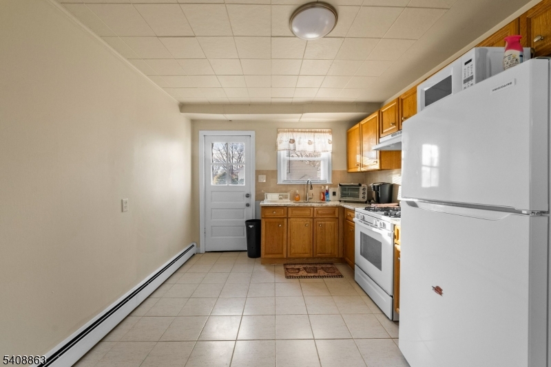 973 Ellis Parkway Edison, NJ 08820 - Photo 9 of 33 a kitchen with a refrigerator a stove top oven and a window