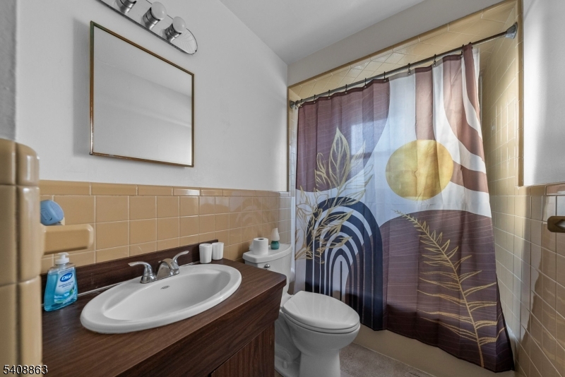 973 Ellis Parkway Edison, NJ 08820 - Photo 10 of 33 a bathroom with a sink a mirror and a toilet