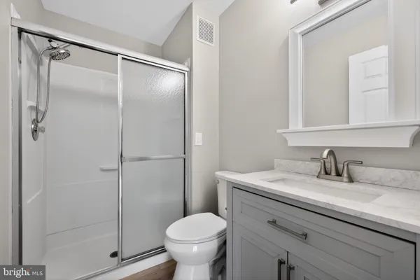 a bathroom with a granite countertop sink toilet and shower