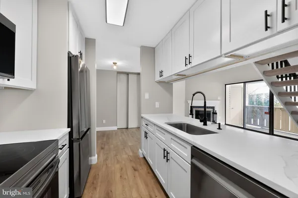 a kitchen with stainless steel appliances a sink stove and cabinets