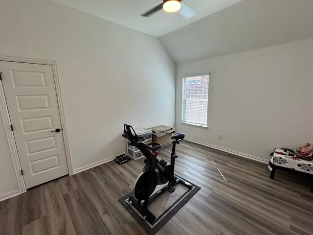 a room with wooden floor and gym equipment