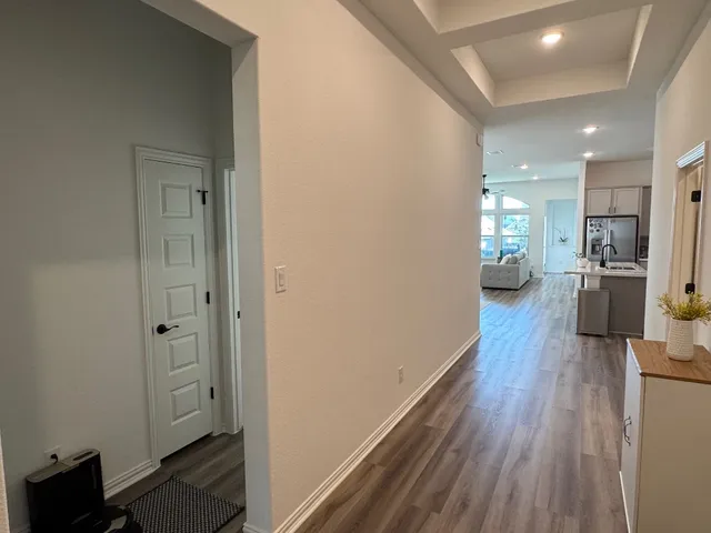 view of a hallway with wooden floor windows and a livingroom