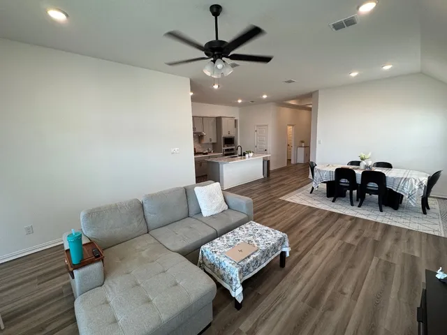 a living room with furniture and a wooden floor