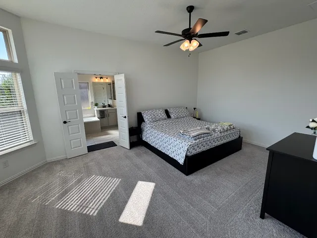 a bedroom with a bed and a ceiling fan