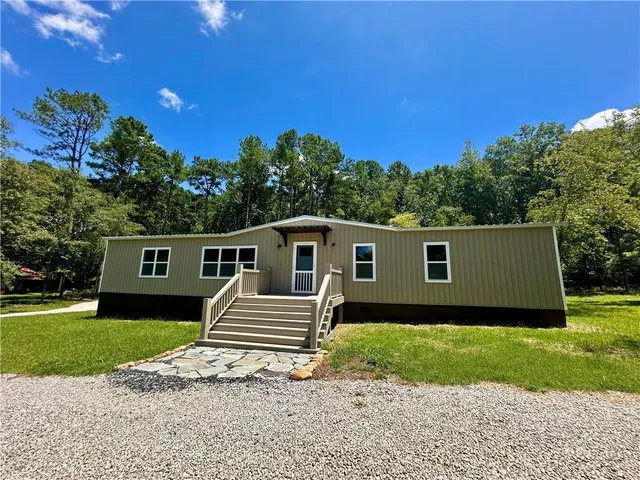a house with green field in front of it