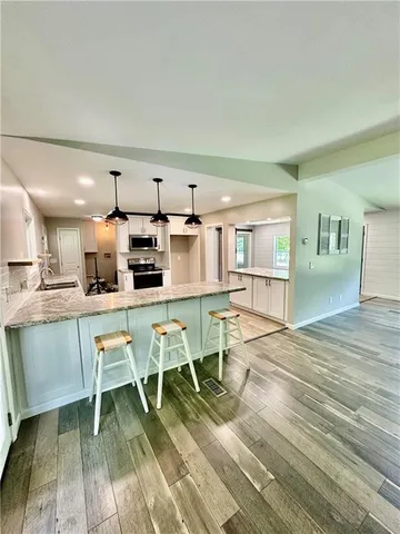 a kitchen with a dining table chairs and refrigerator