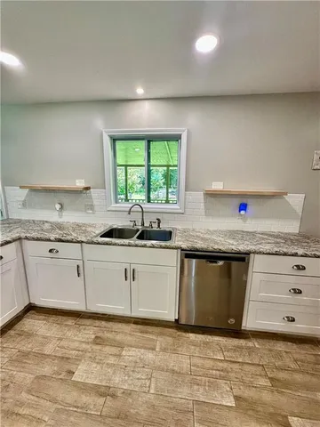 a kitchen with stainless steel appliances granite countertop a sink stove and cabinets