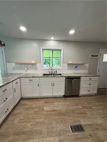 a kitchen with stainless steel appliances a sink stove and cabinets