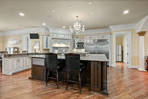 a living room with stainless steel appliances granite countertop a stove top oven a sink and a fireplace