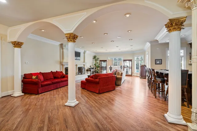 a kitchen with stainless steel appliances granite countertop a stove top oven a sink a dining table and chairs with wooden floor