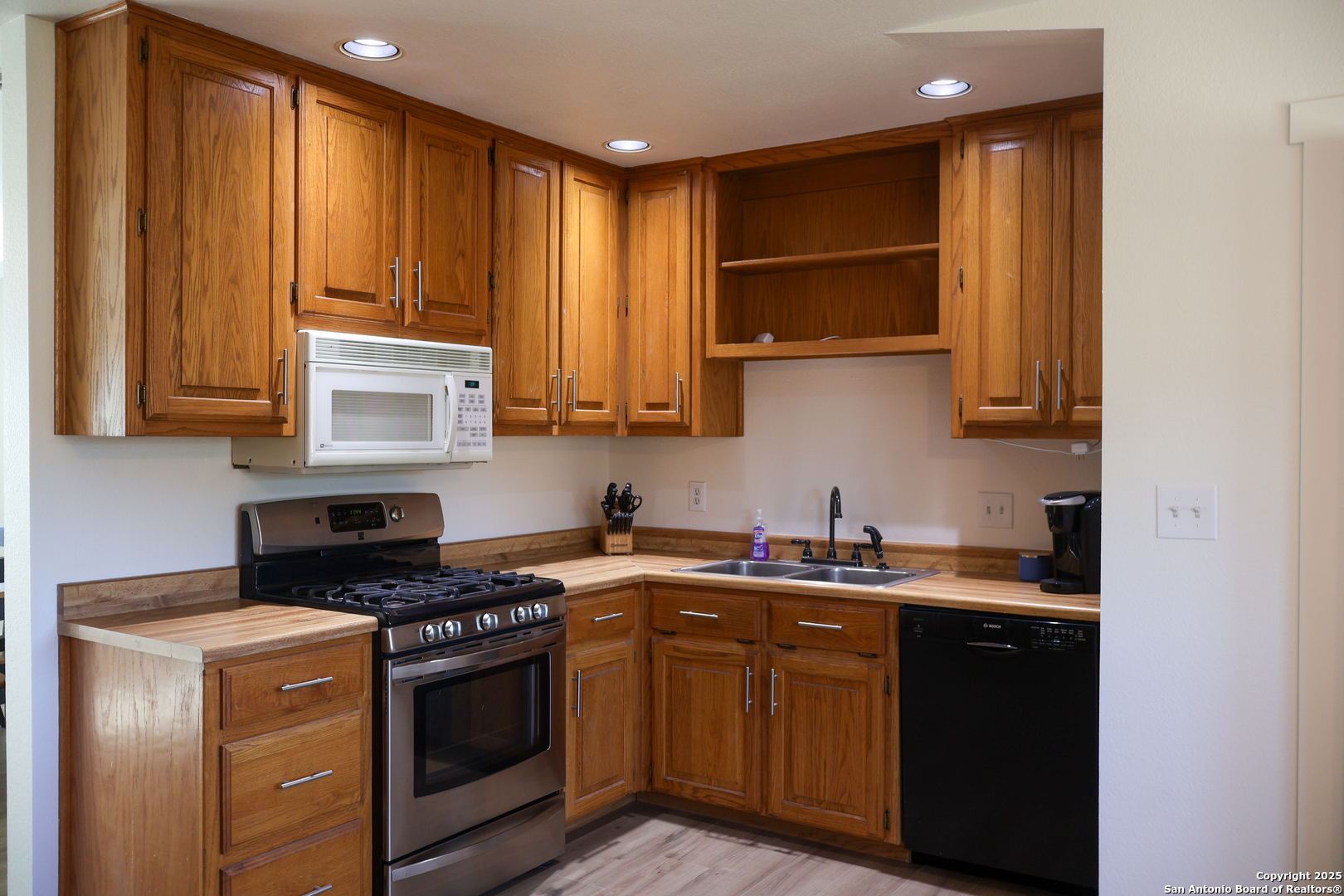 1031 Shin Oak Road Menard, TX 76859 - Photo 15 of 31 a kitchen with stainless steel appliances granite countertop a stove a sink and a microwave