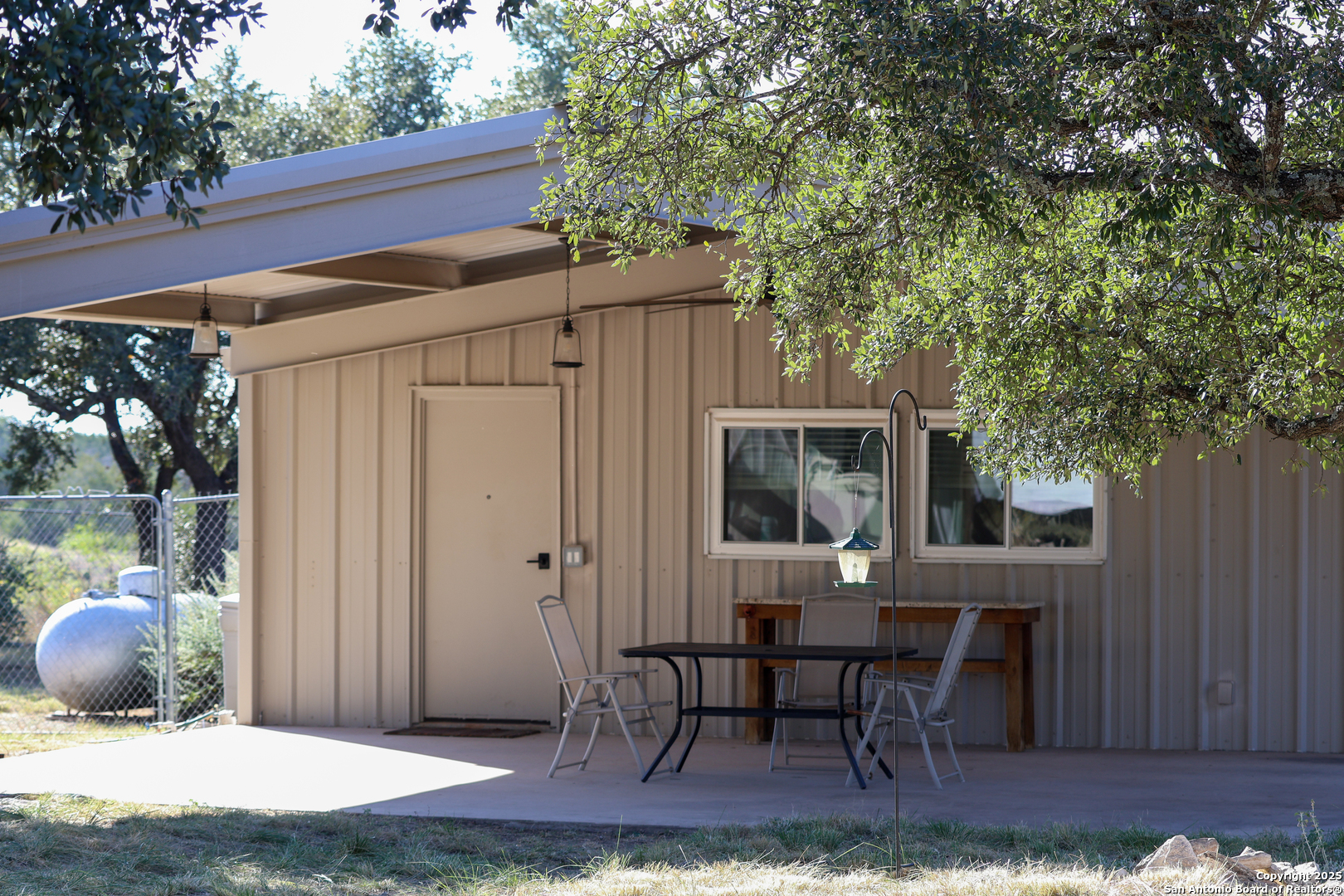 1031 Shin Oak Road Menard, TX 76859 - Photo 24 of 31 a view of a patio with table and chairs with wooden fence and large trees