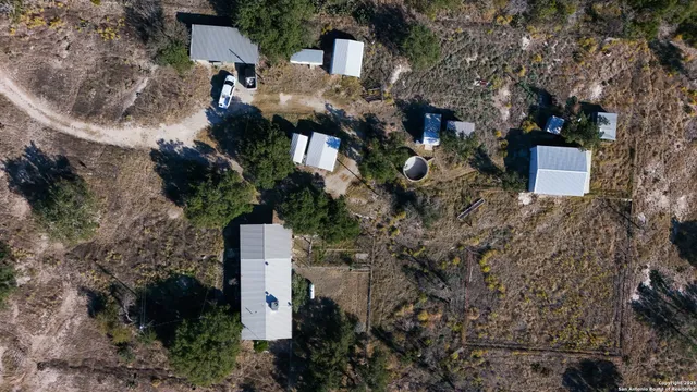 an aerial view of a house with a yard and tree s