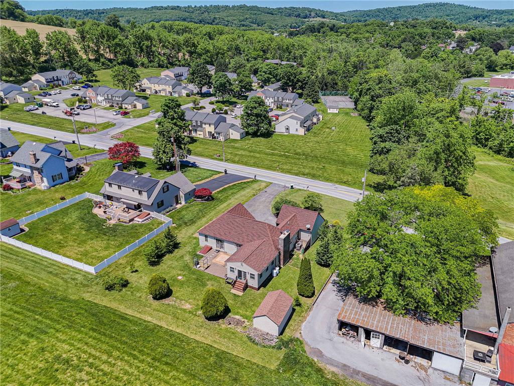 652 Old State Road Oley, PA 19547 - Photo 48 of 54 An aerial perspective reveals a charming property nestled amidst green lawns and a tree-lined backdrop.