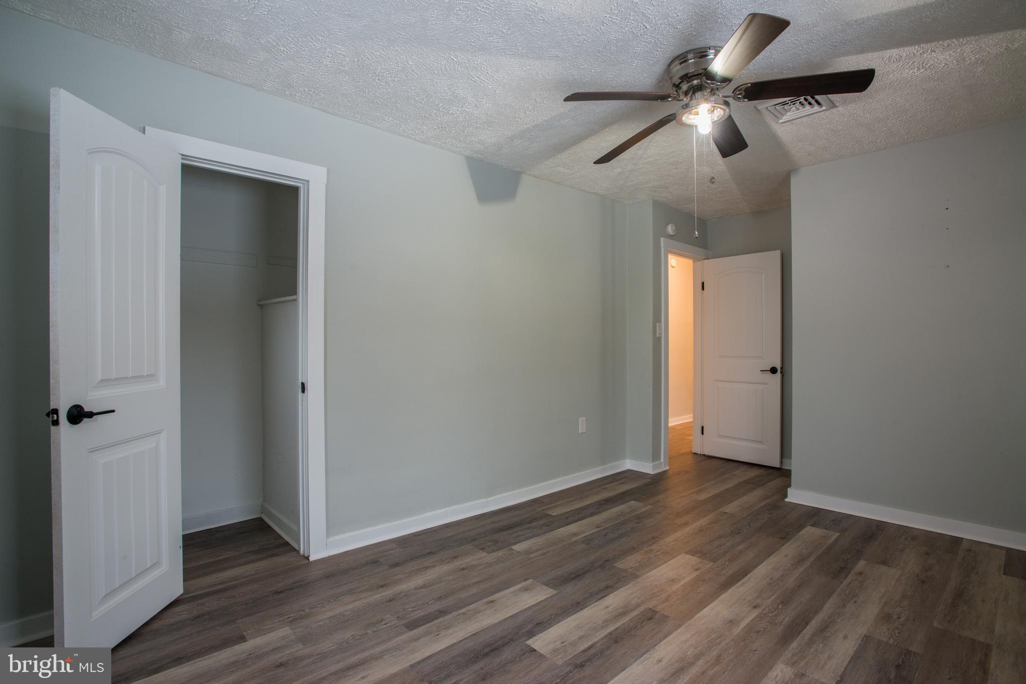 99 East Perry Street Enola, PA 17025 - Photo 11 of 18 an empty room with wooden floor fan and windows