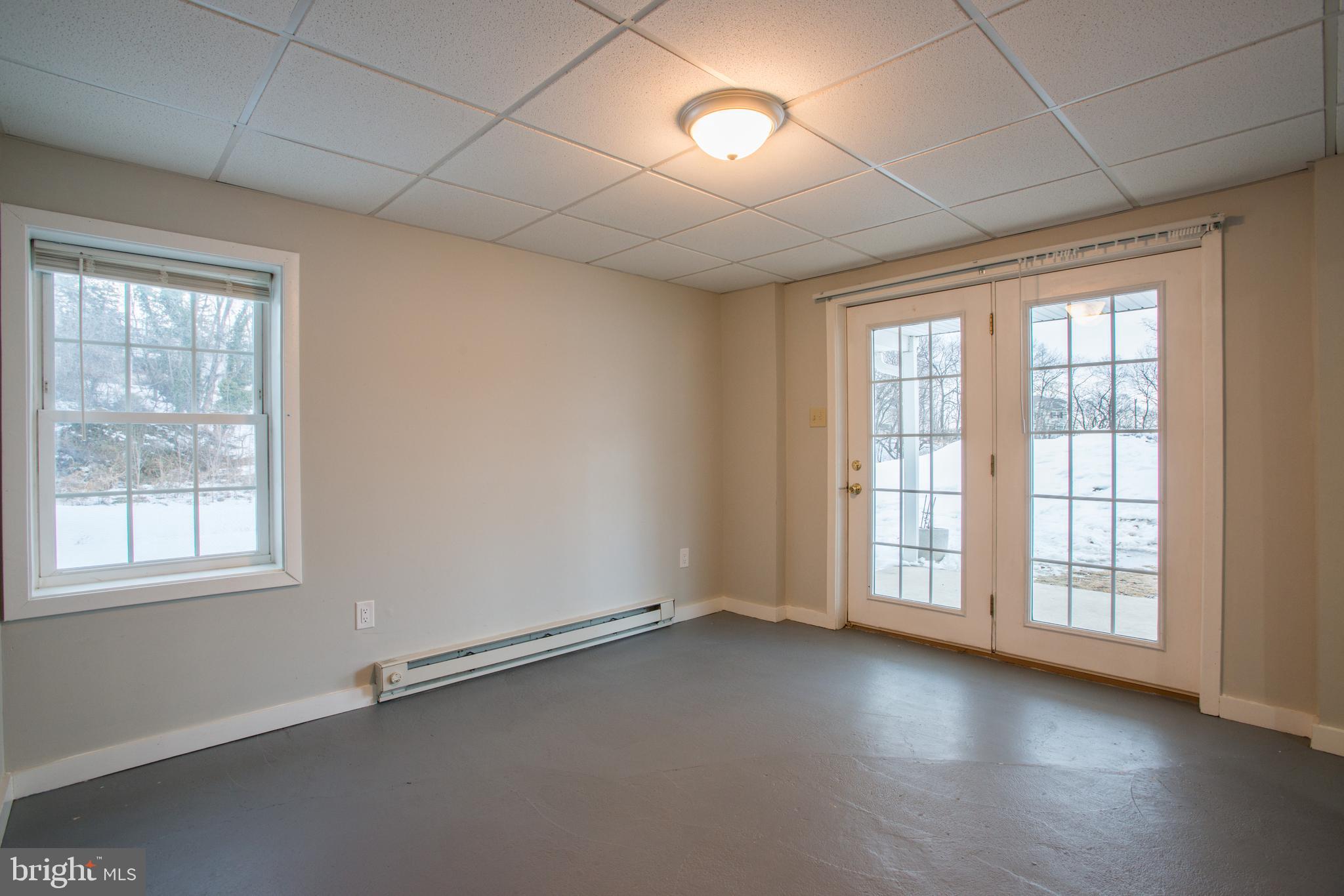 99 East Perry Street Enola, PA 17025 - Photo 15 of 18 an empty room with wooden floor and windows with curtains