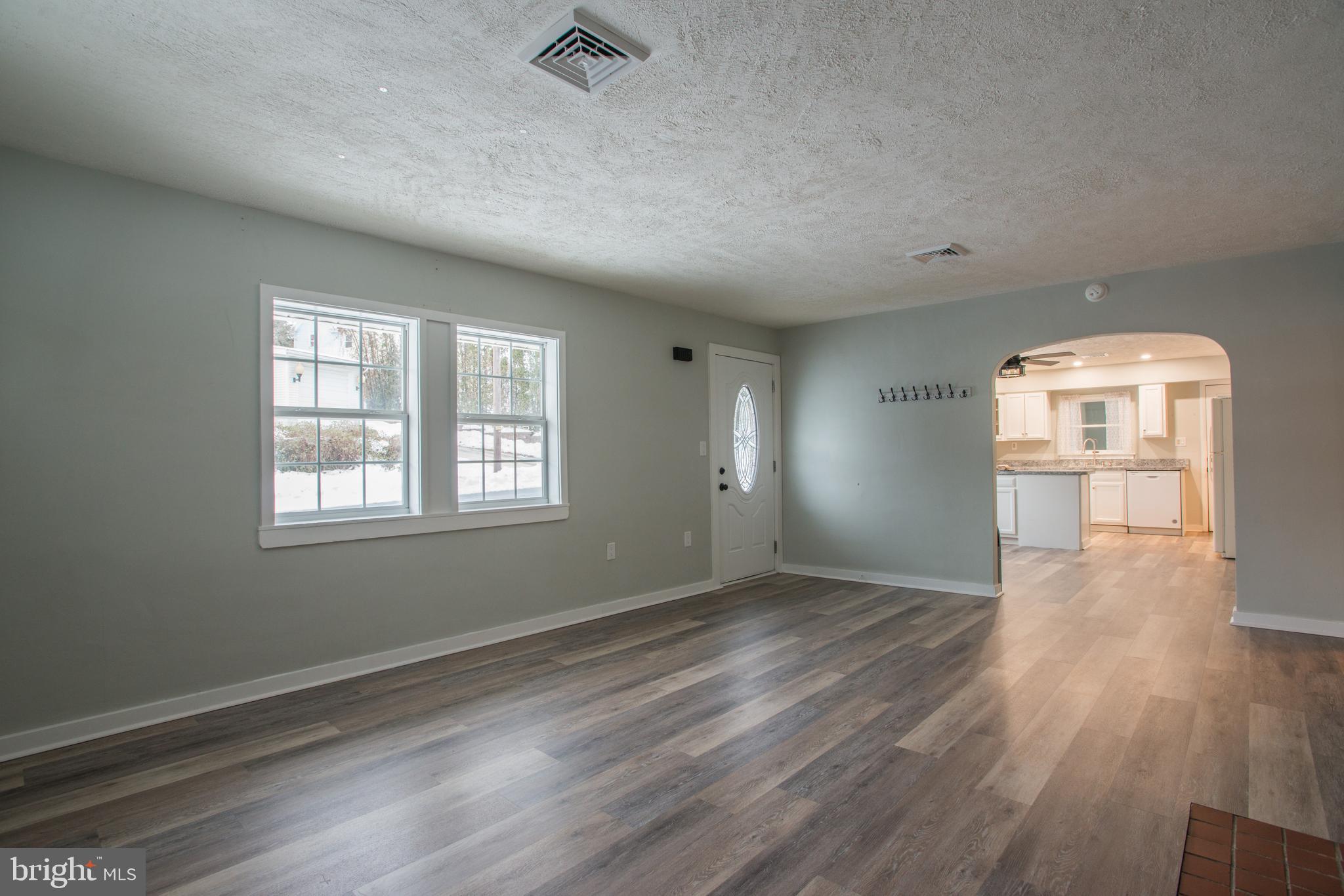 99 East Perry Street Enola, PA 17025 - Photo 3 of 18 an empty room with wooden floor and windows