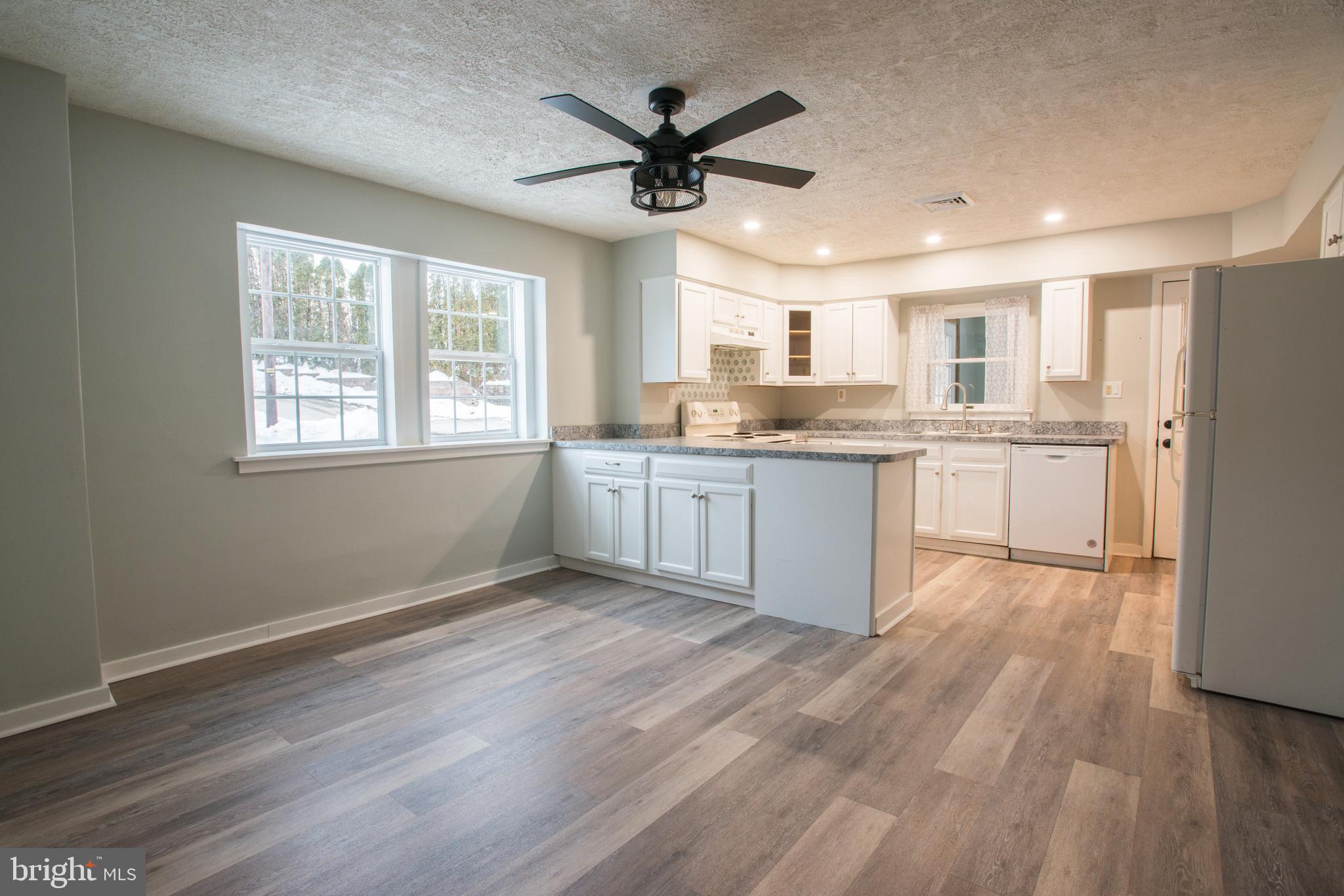 99 East Perry Street Enola, PA 17025 - Photo 4 of 18 a kitchen with granite countertop appliances cabinets and a wooden floor