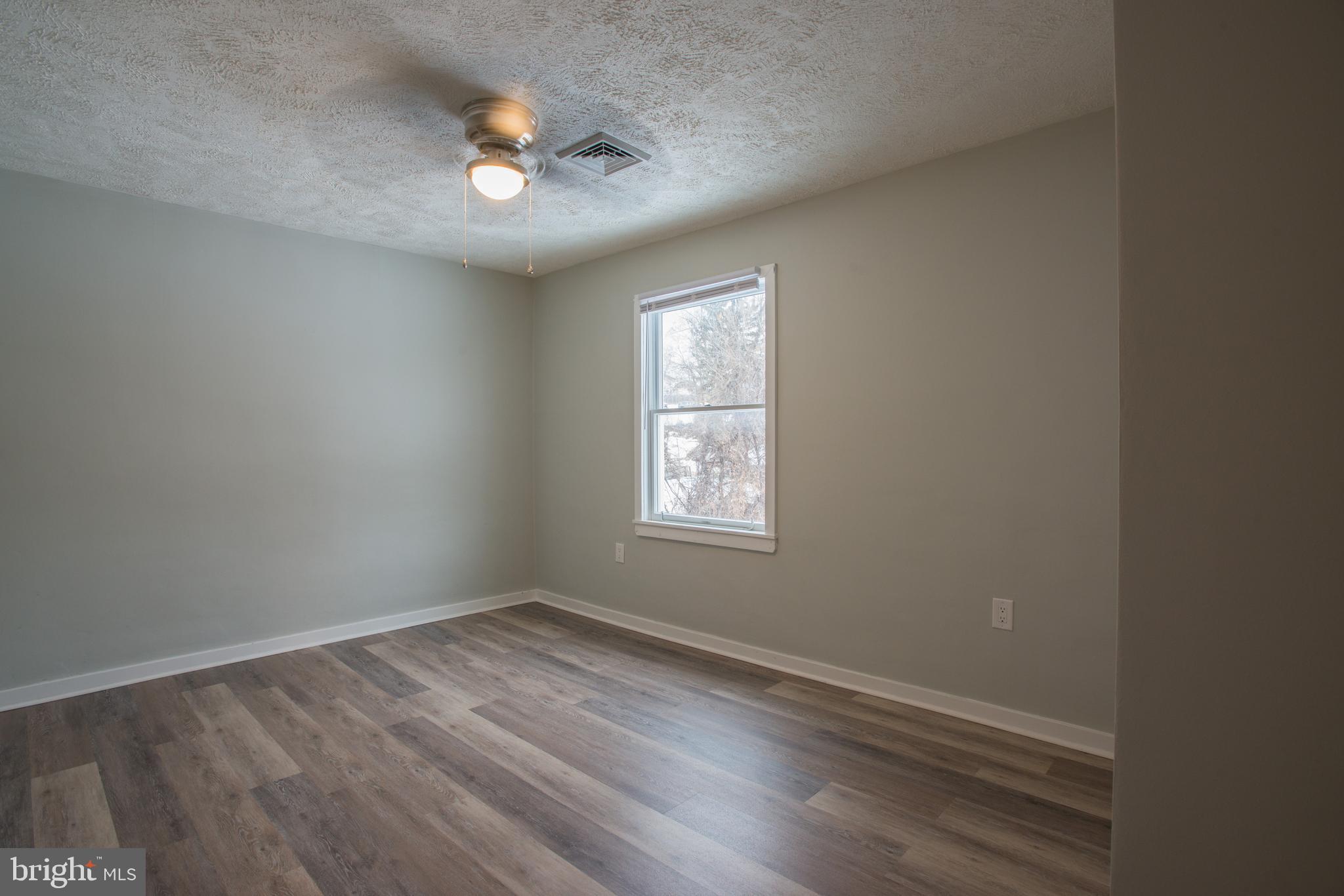 99 East Perry Street Enola, PA 17025 - Photo 7 of 18 an empty room with wooden floor and windows