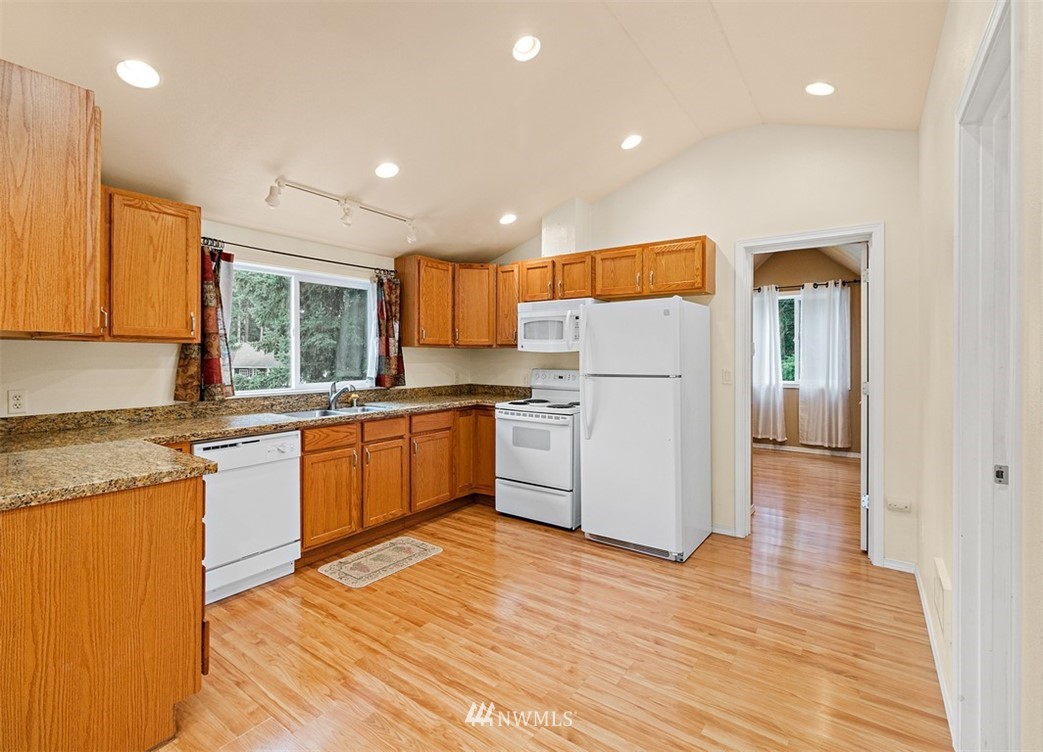 18811 Nutmeg Street Southwest Rochester, WA 98579 - Photo 22 of 25 a kitchen with granite countertop appliances a sink and a refrigerator