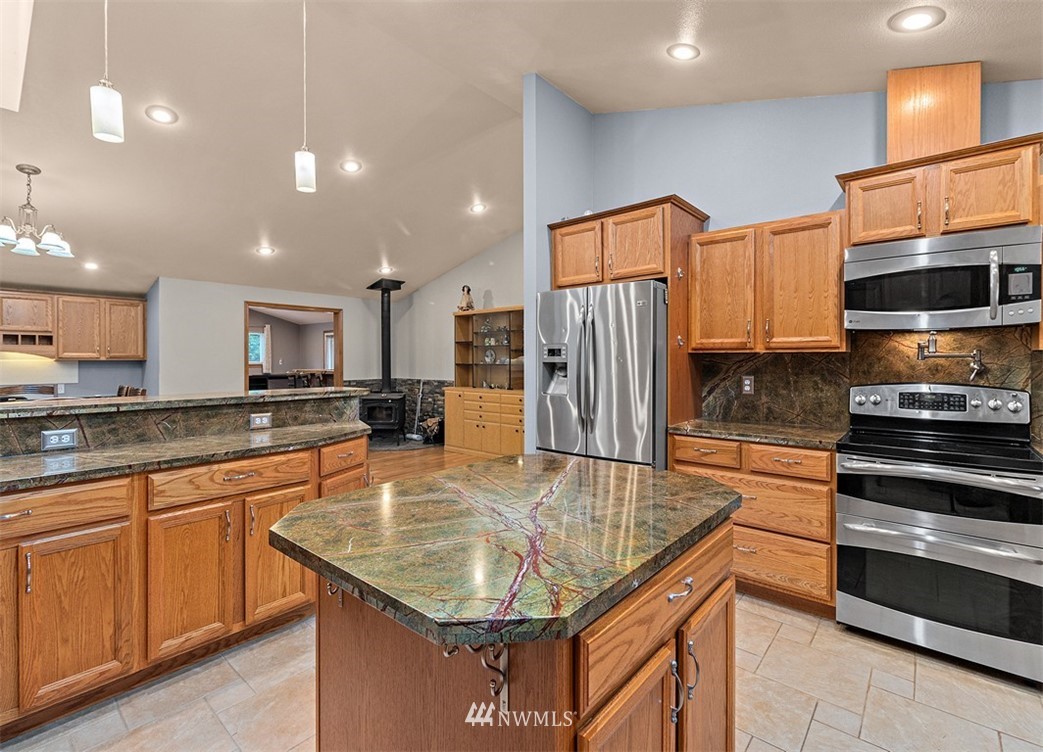 18811 Nutmeg Street Southwest Rochester, WA 98579 - Photo 10 of 25 a kitchen with stainless steel appliances granite countertop a sink refrigerator and microwave