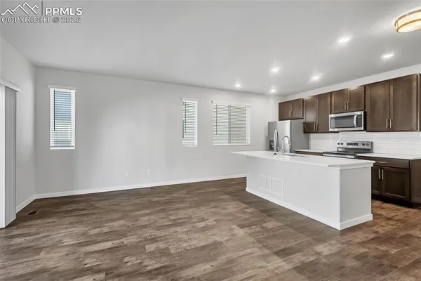 a kitchen with granite countertop a stove top oven a sink and a refrigerator