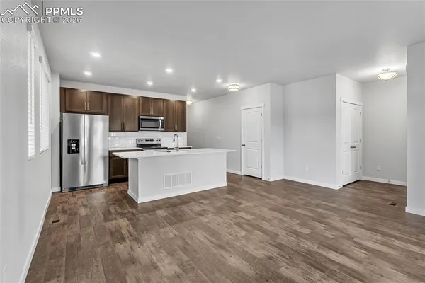 a view of kitchen with refrigerator sink microwave and cabinets
