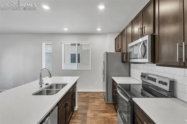 a kitchen with stainless steel appliances granite countertop a sink stove and refrigerator