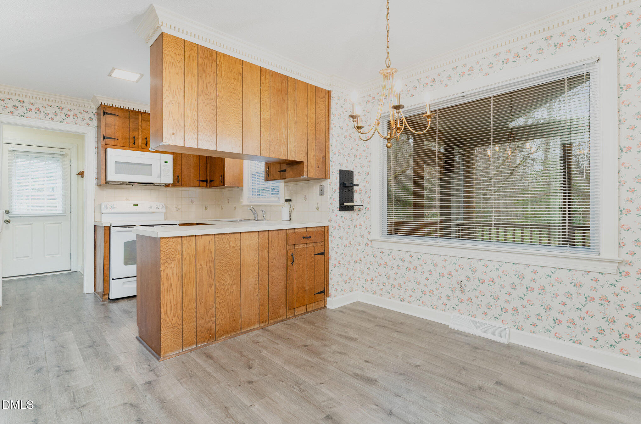 1100 Sudbury Court Raleigh, NC 27609 - Photo 34 of 56 a kitchen with kitchen island granite countertop a stove a sink and white cabinets with wooden floor