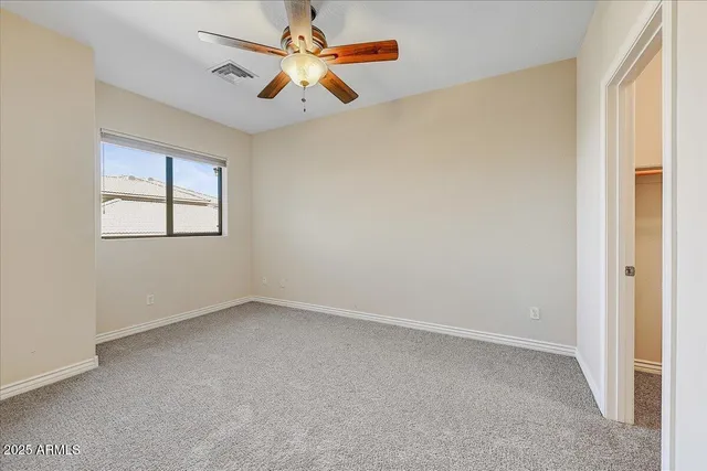 an empty room with windows and fan