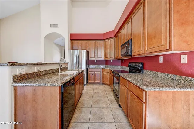 a kitchen with stainless steel appliances granite countertop a sink and a counter