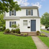 a front view of a house with a garden and yard