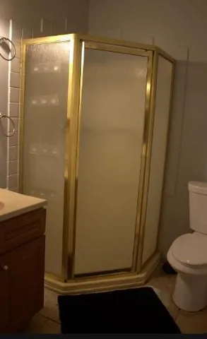 a bathroom with a glass door shower and a toilet