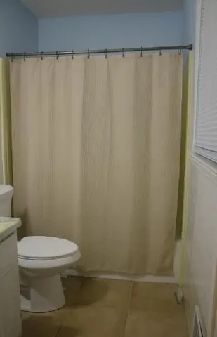 a white toilet sitting next to a shower