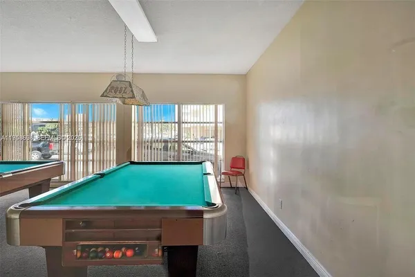 a room with pool table and windows