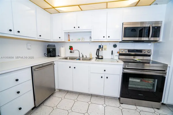 a kitchen with stainless steel appliances granite countertop a sink a stove and microwave