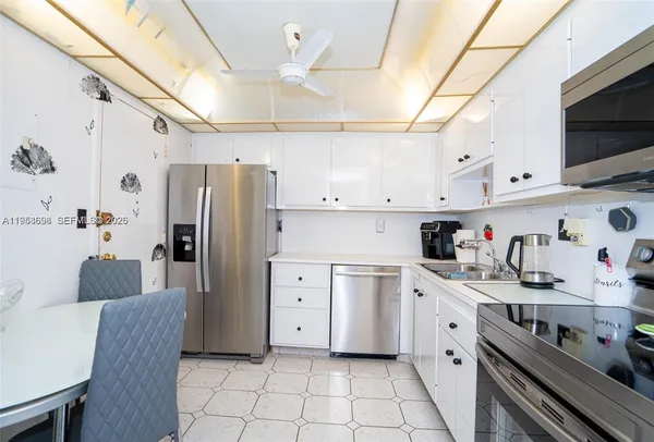 a kitchen with stainless steel appliances a refrigerator sink and cabinets