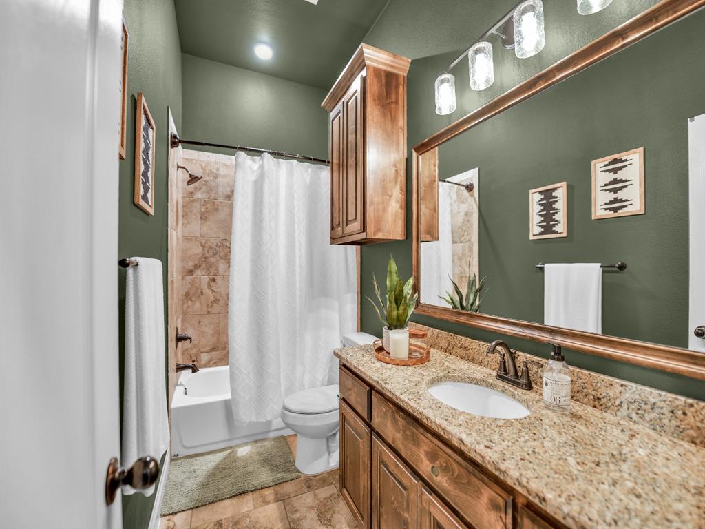 156 Cottongame Road Weatherford, TX 76088 - Photo 22 of 35 a bathroom with a granite countertop sink toilet and shower
