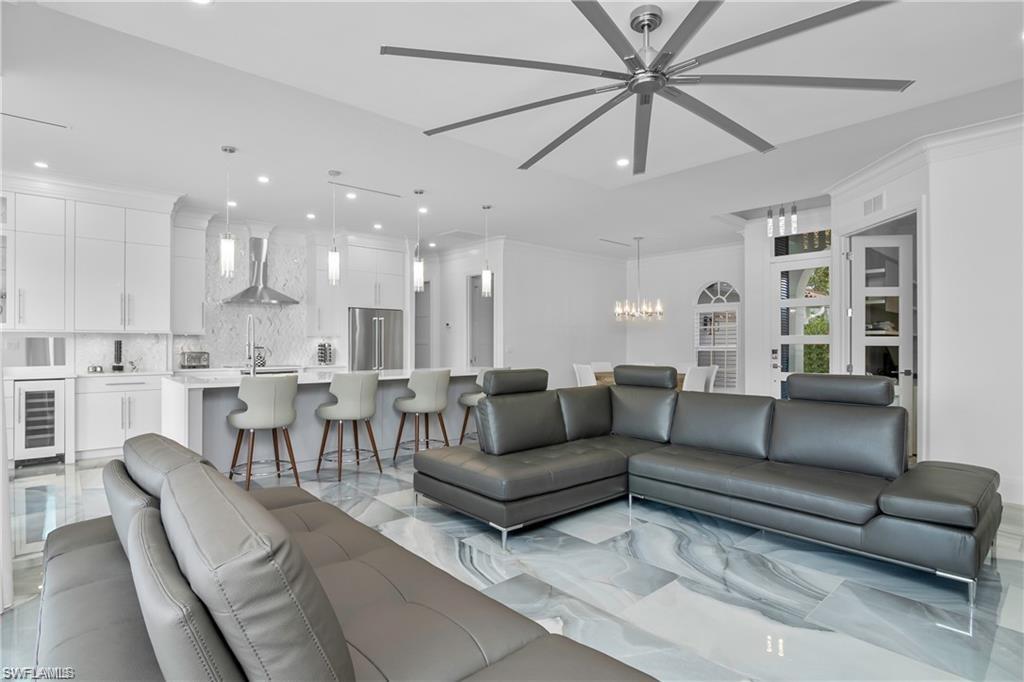 8967 Lely Island Circle Naples, FL 34113 - Photo 13 of 46 a living room with furniture and a view of kitchen