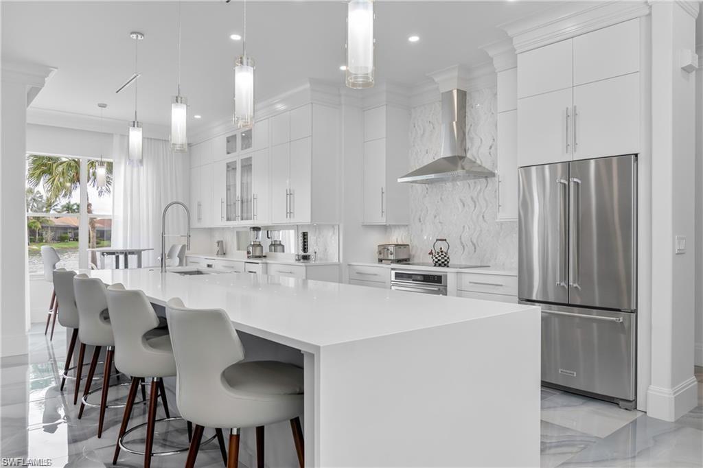 8967 Lely Island Circle Naples, FL 34113 - Photo 16 of 46 a kitchen with stainless steel appliances a sink stove and refrigerator
