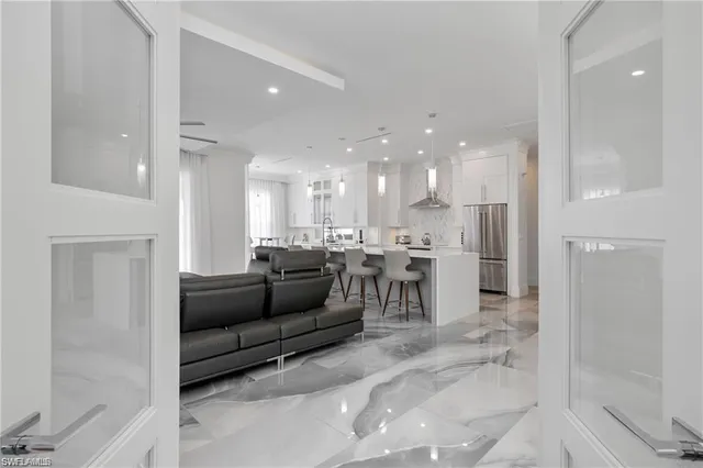 a living room with furniture and a view of kitchen