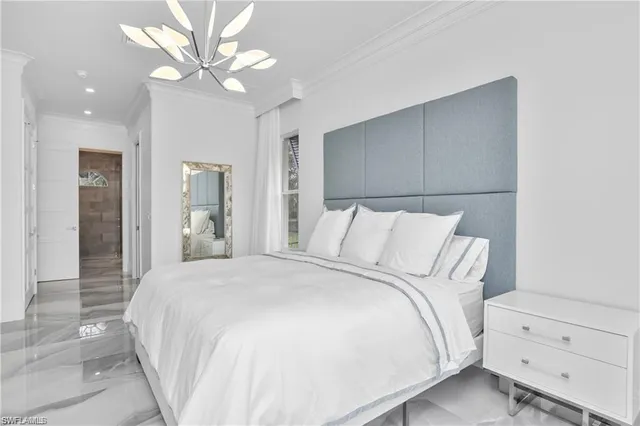 a spacious bedroom with a bed and a chandelier