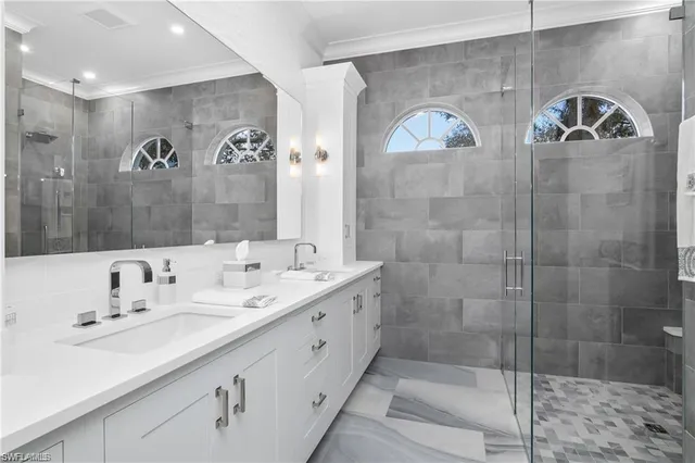 a bathroom with a double vanity sink mirror and shower