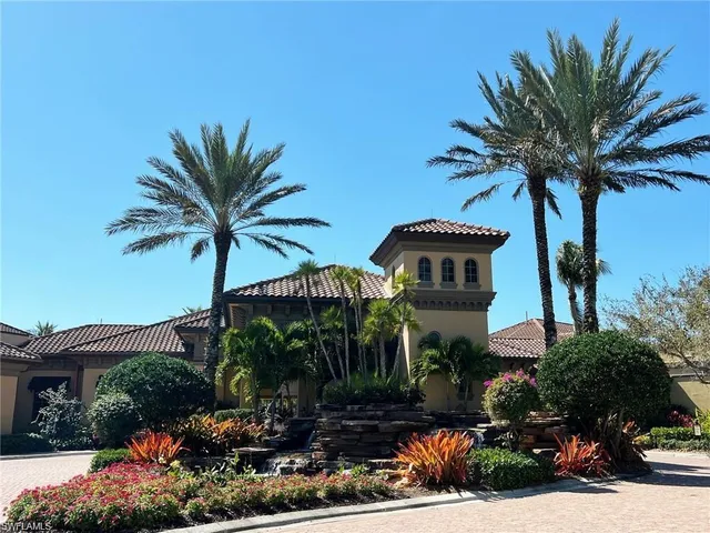 a front view of a house with a yard and palm trees
