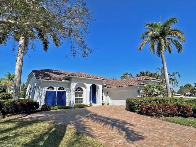 a view of a house with a yard and potted plants