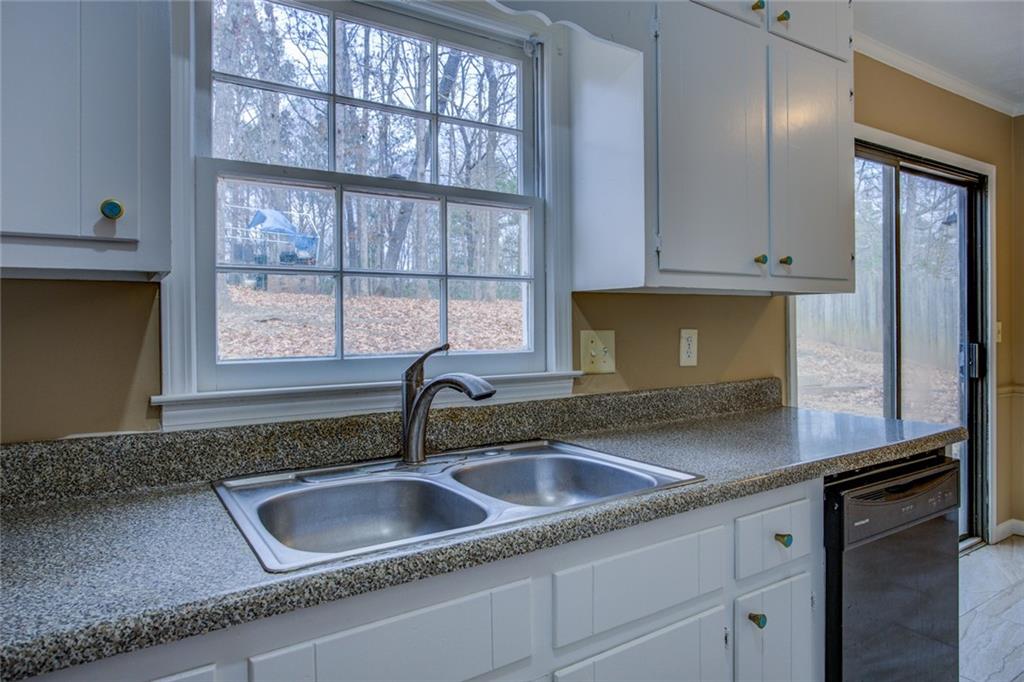 1457 Cherry Hill Road Southwest Conyers, GA 30094 - Photo 16 of 31 a kitchen with granite countertop a sink and a window