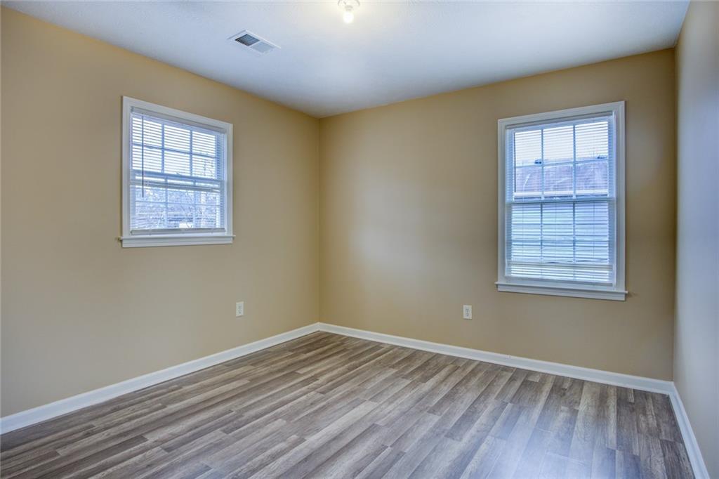 1457 Cherry Hill Road Southwest Conyers, GA 30094 - Photo 26 of 31 a view of an empty room with wooden floor and a window